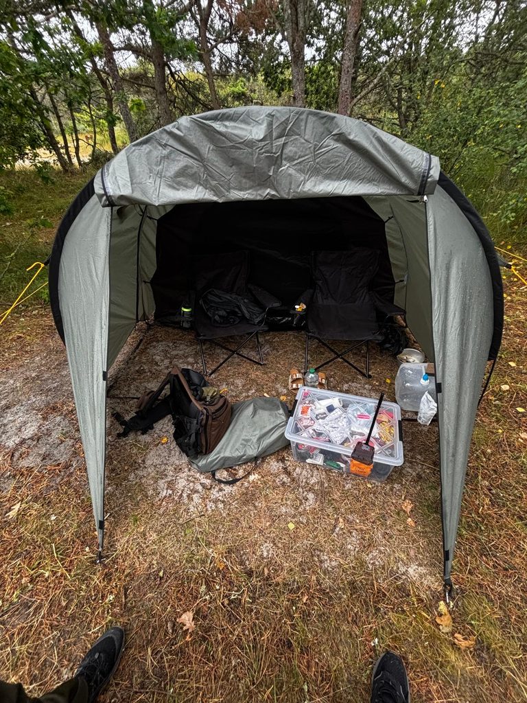 Tent, camping chairs and gear set up at a campsite in Denmark